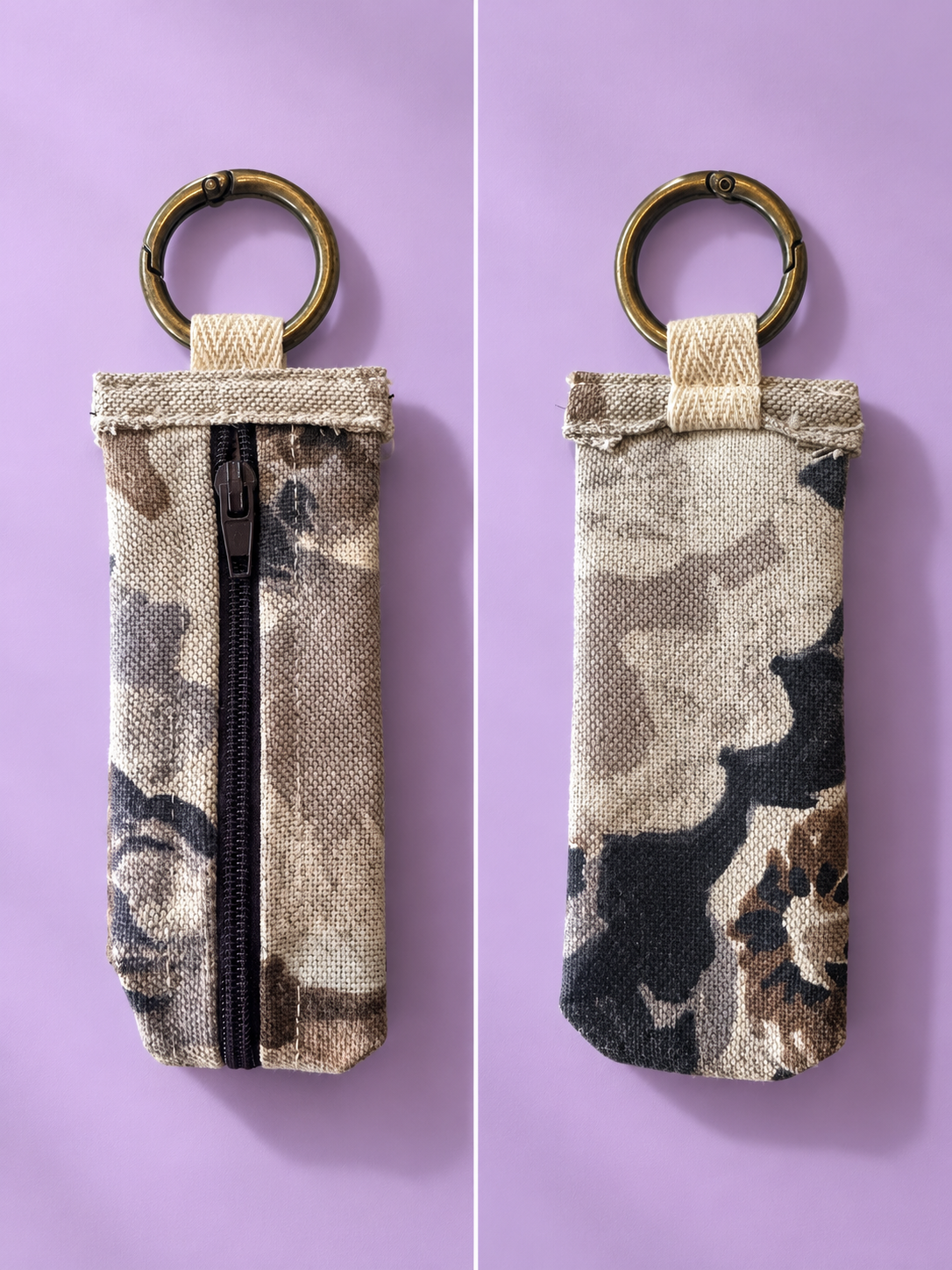 Front and back views of a beige and charcoal camouflage keychain pouch with a black zipper and brass-tone key ring