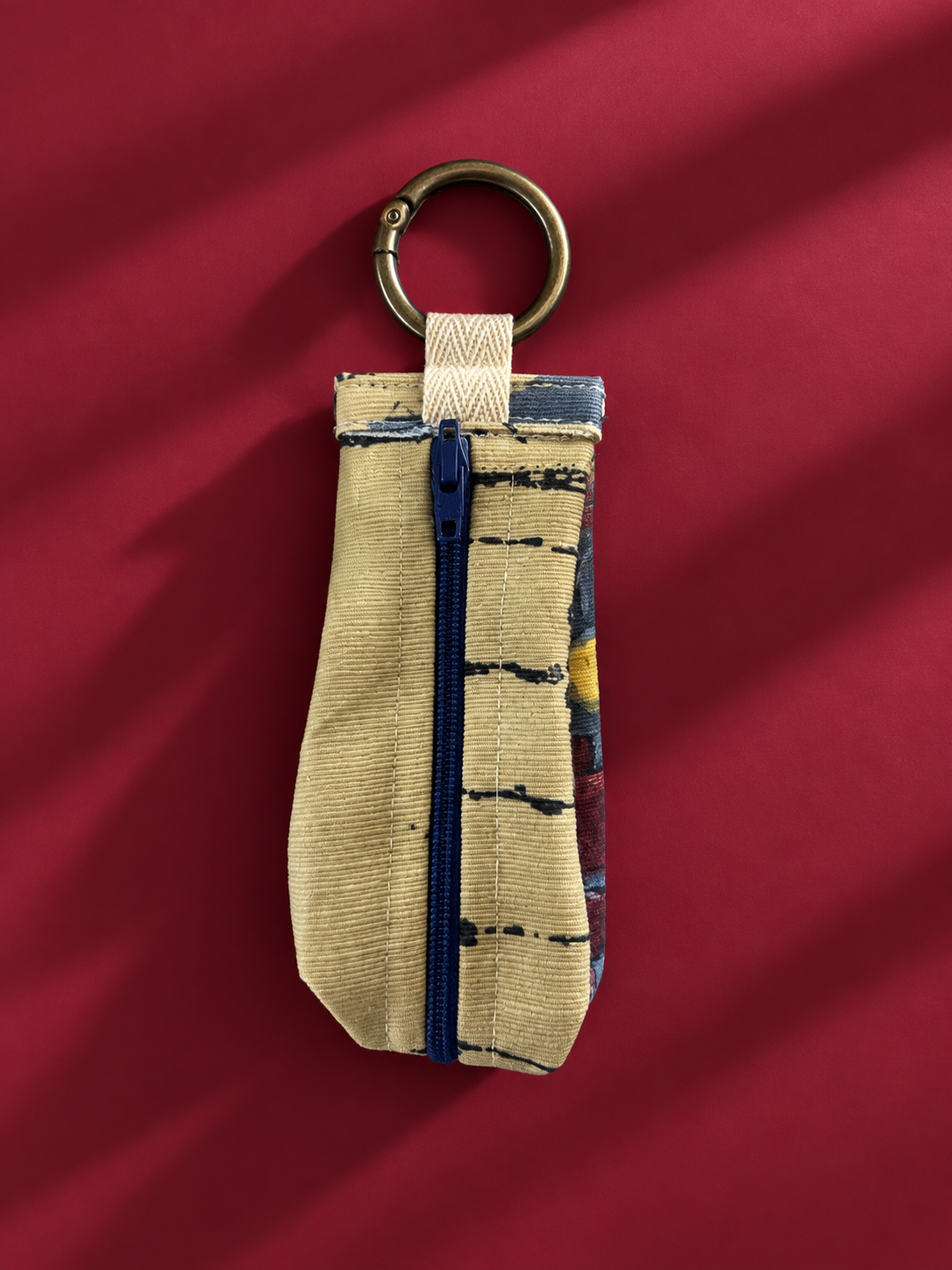 Back of upcycled keychain pouch showing blue zipper and metal key ring