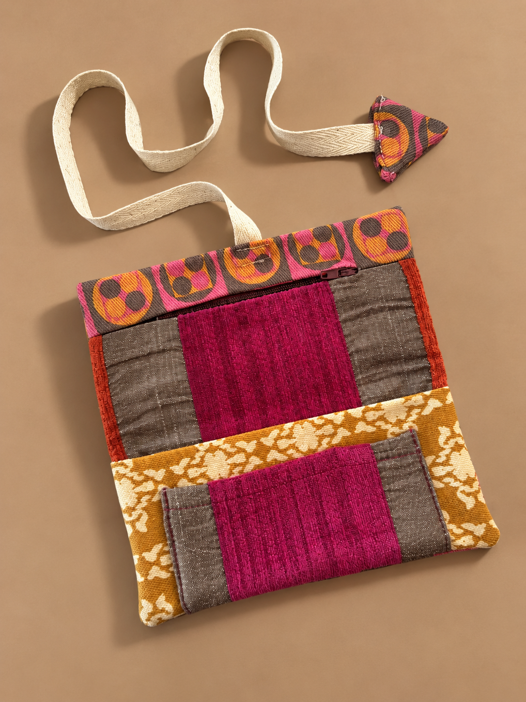 Patchwork side of pouch with magenta and grey panels, gold floral trim and a zip pocket