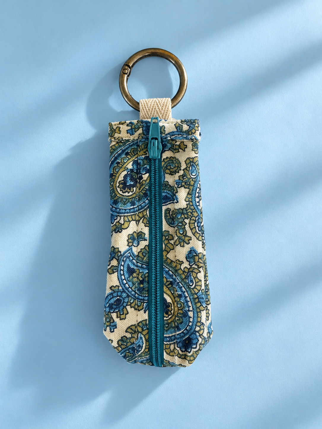 Blue and cream paisley keychain pouch with a teal zipper and brass-tone metal key ring