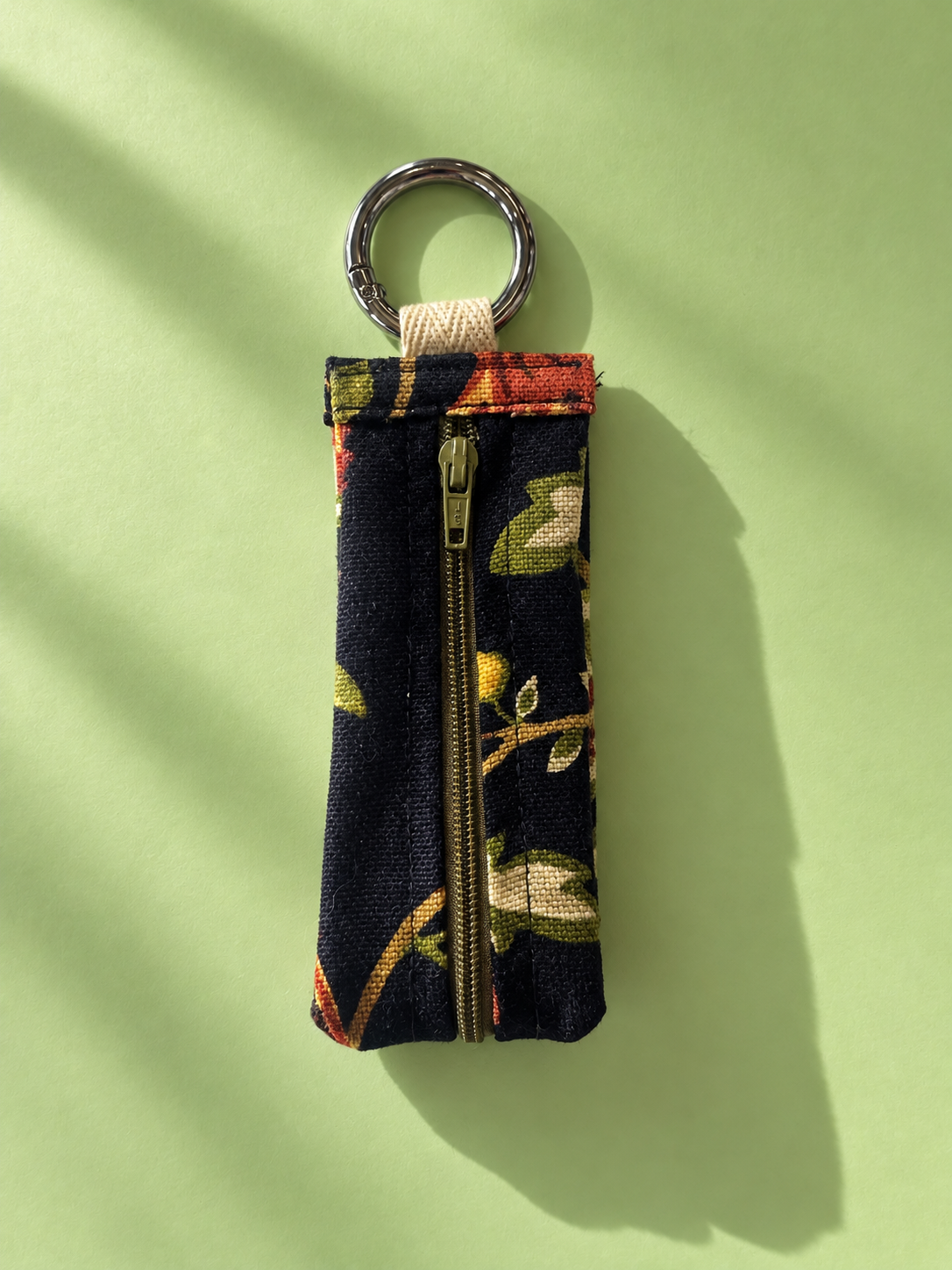 Dark floral tapestry keychain pouch with a zipper and silver-tone metal key ring