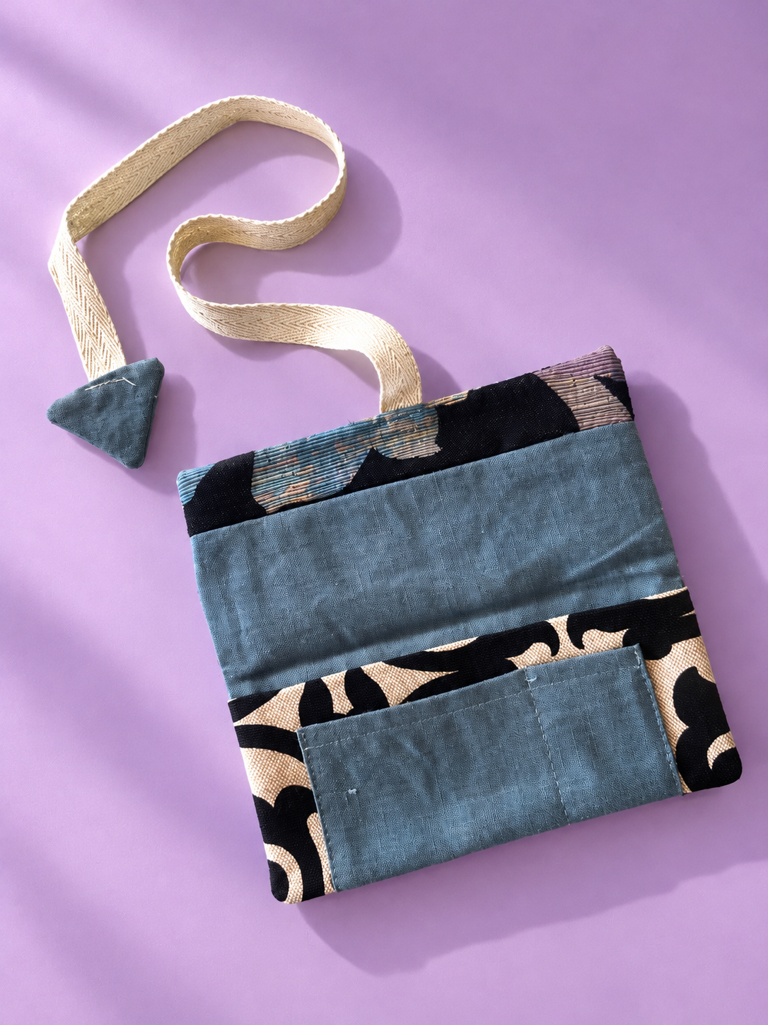 Slate blue patchwork reverse with black and cream patterned panels and slate blue pocket
