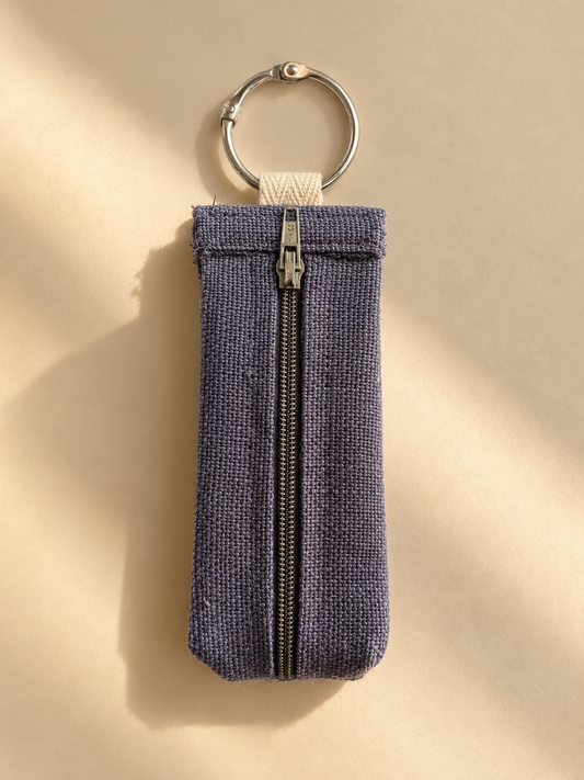 Slate-purple woven keychain pouch with a metal zipper and silver-tone key ring