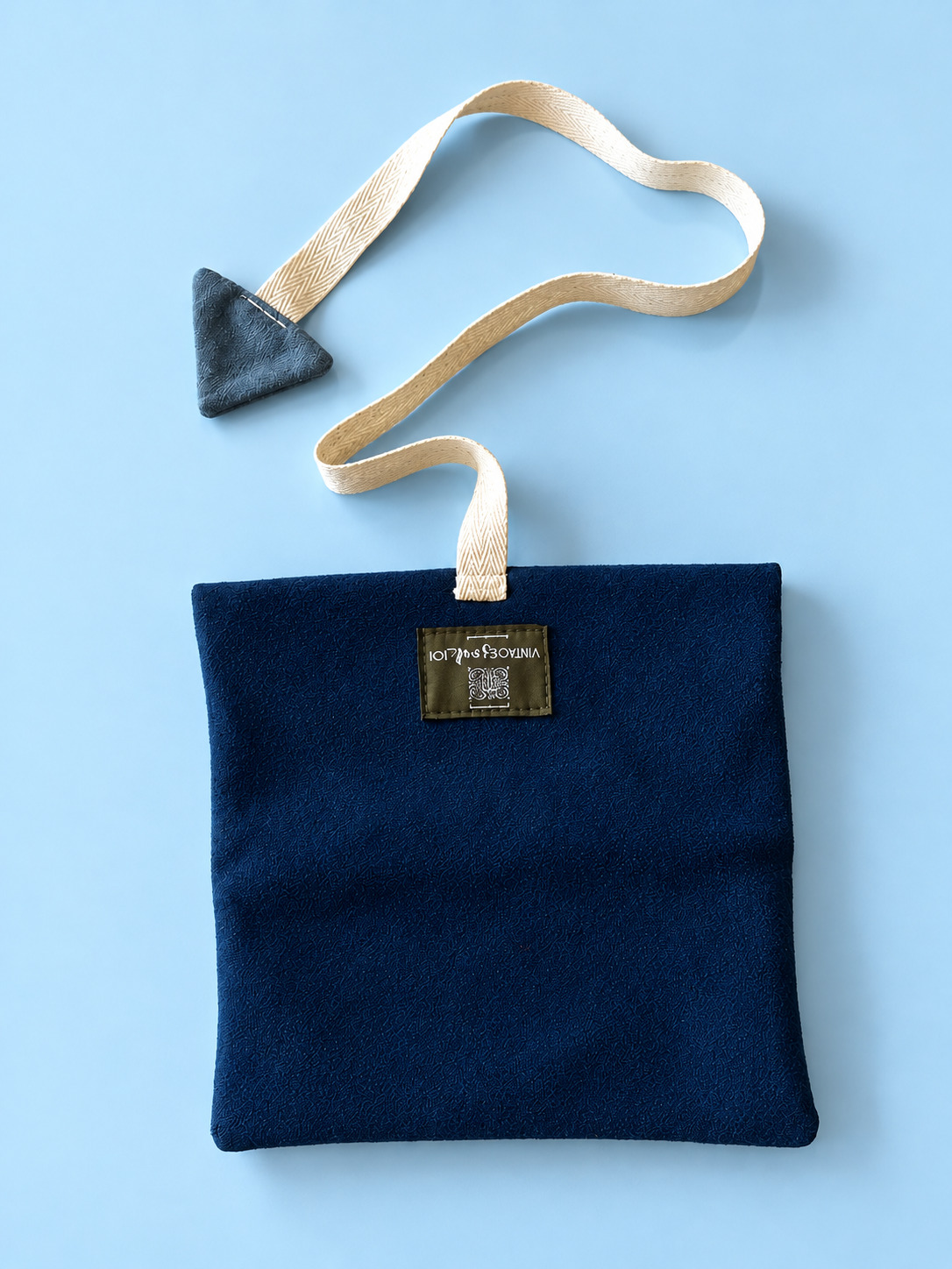 Navy pouch with cream woven strap and slate blue triangular detail