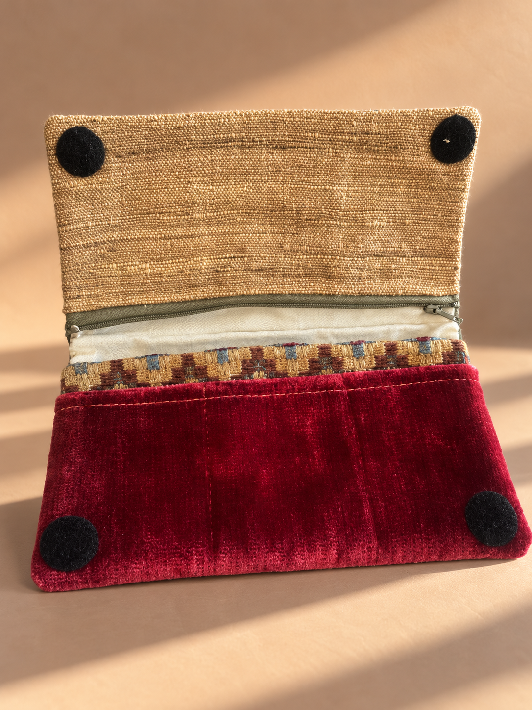 Open Mega-Pouch showing burgundy interior, gold-toned flap and zippered compartment