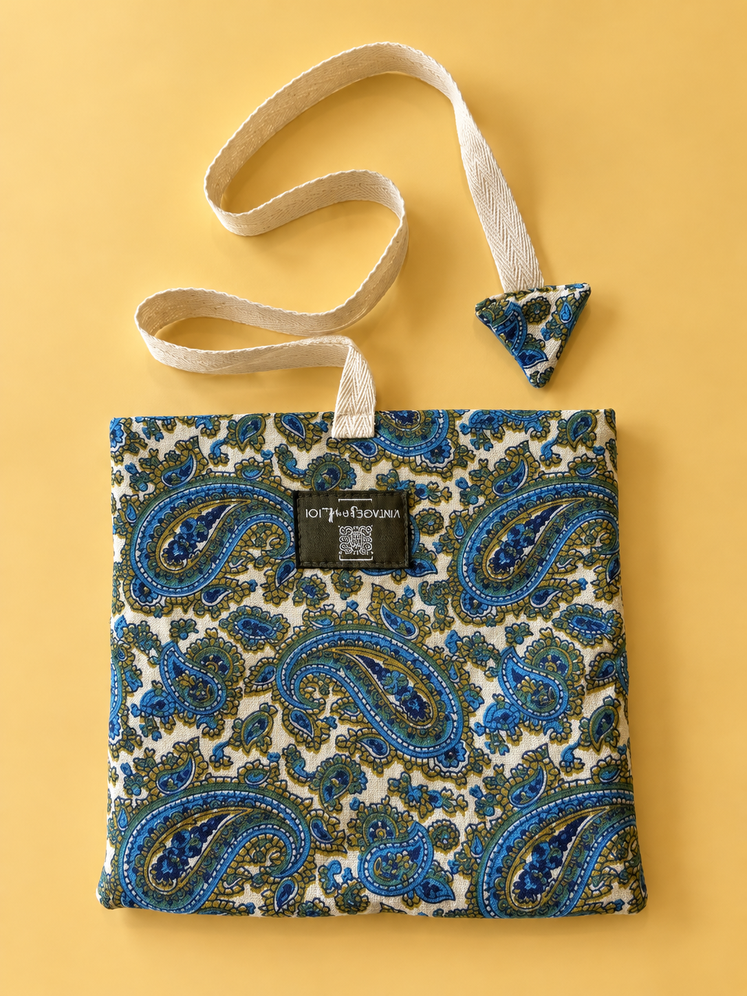 Blue and olive paisley pouch on cream with a cream woven strap and matching triangular detail