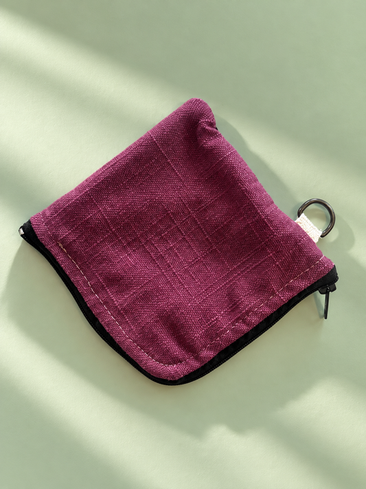 Plum woven reverse of zip pouch with black trim and metal side ring