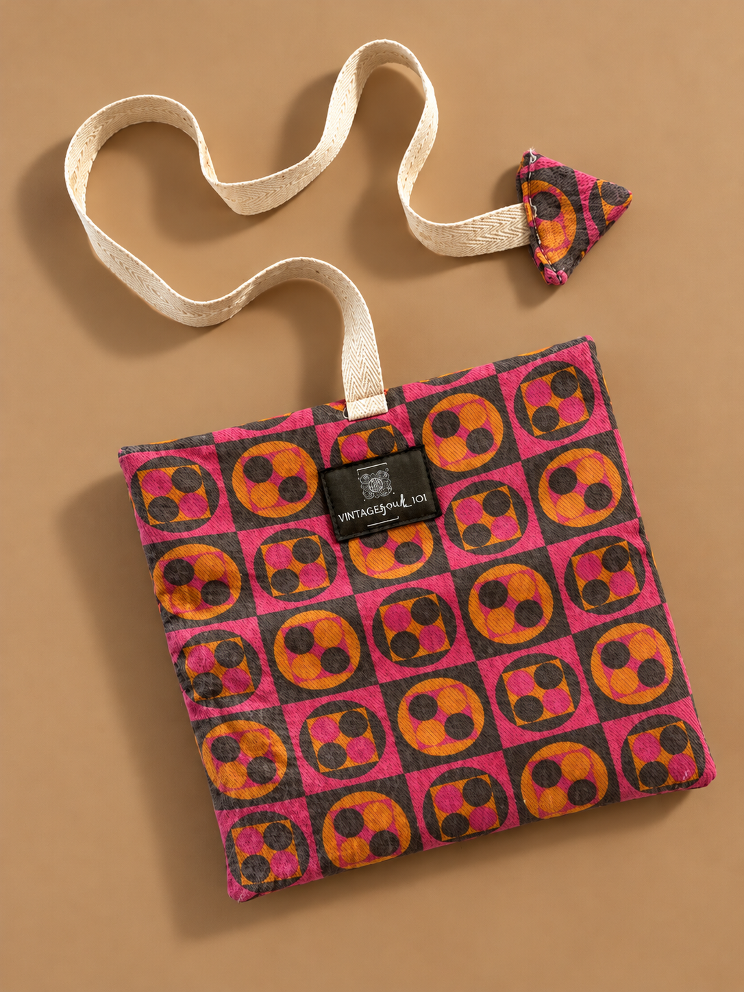 Pink, orange and charcoal geometric pouch with cream woven strap and matching triangular detail