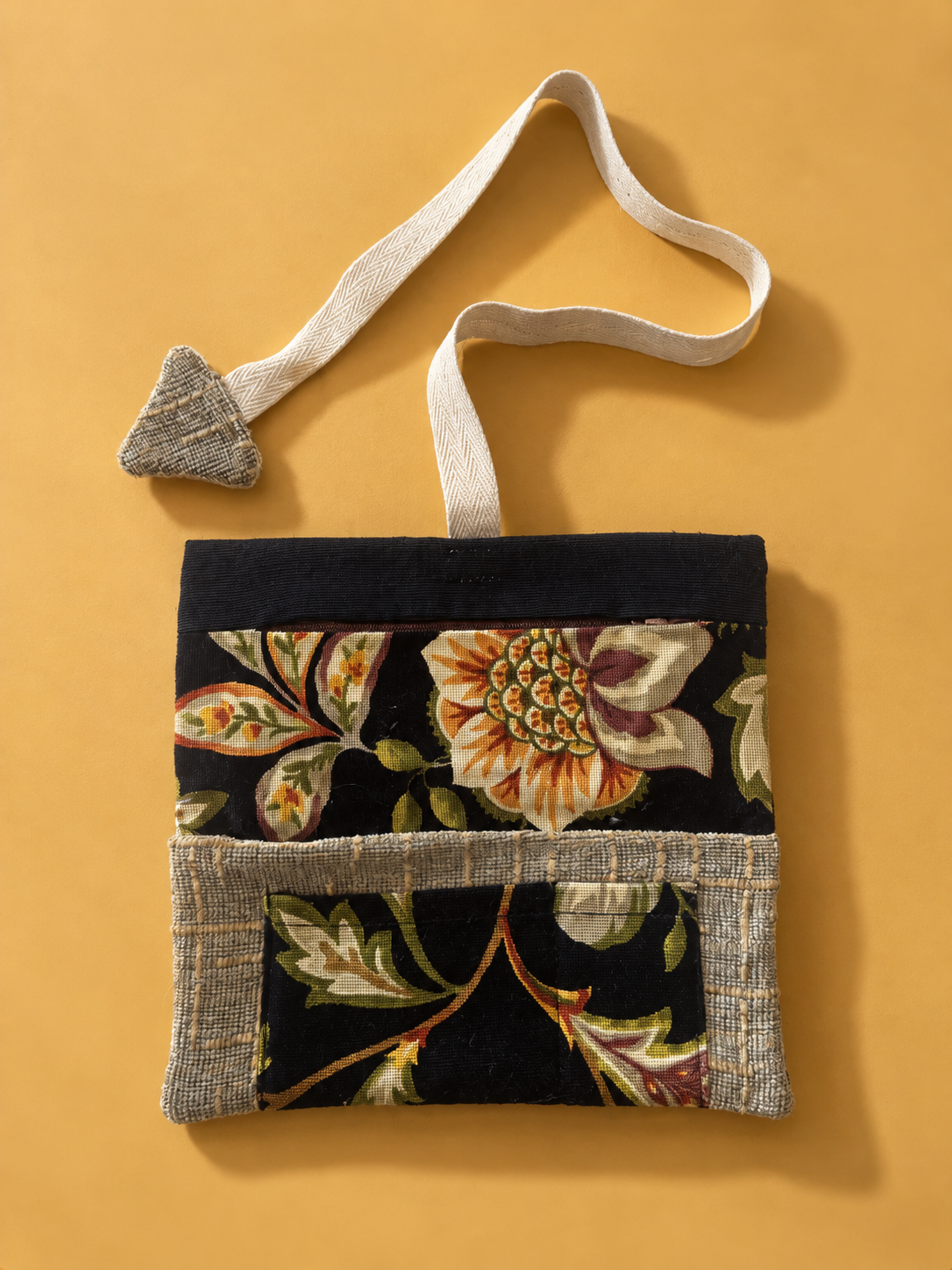 Floral tapestry side of pouch with textured trim and cream woven strap