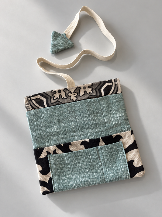 Teal patchwork side of pouch with black and cream patterned panels and teal pocket