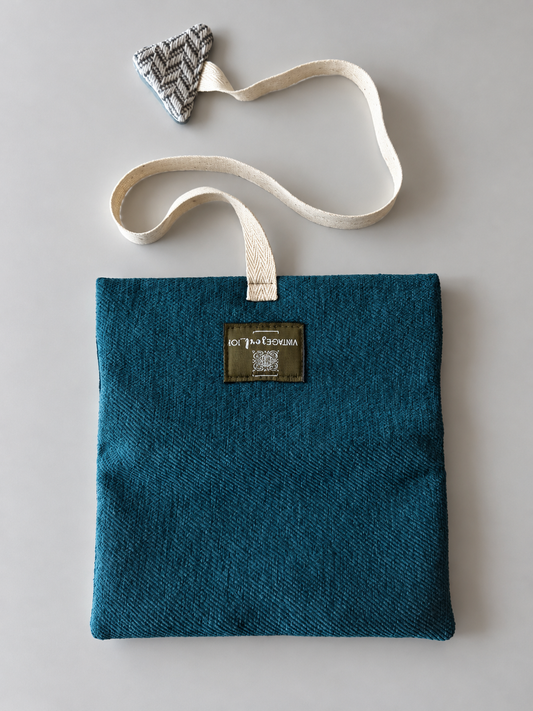 Teal textured pouch with cream woven strap and herringbone triangular detail