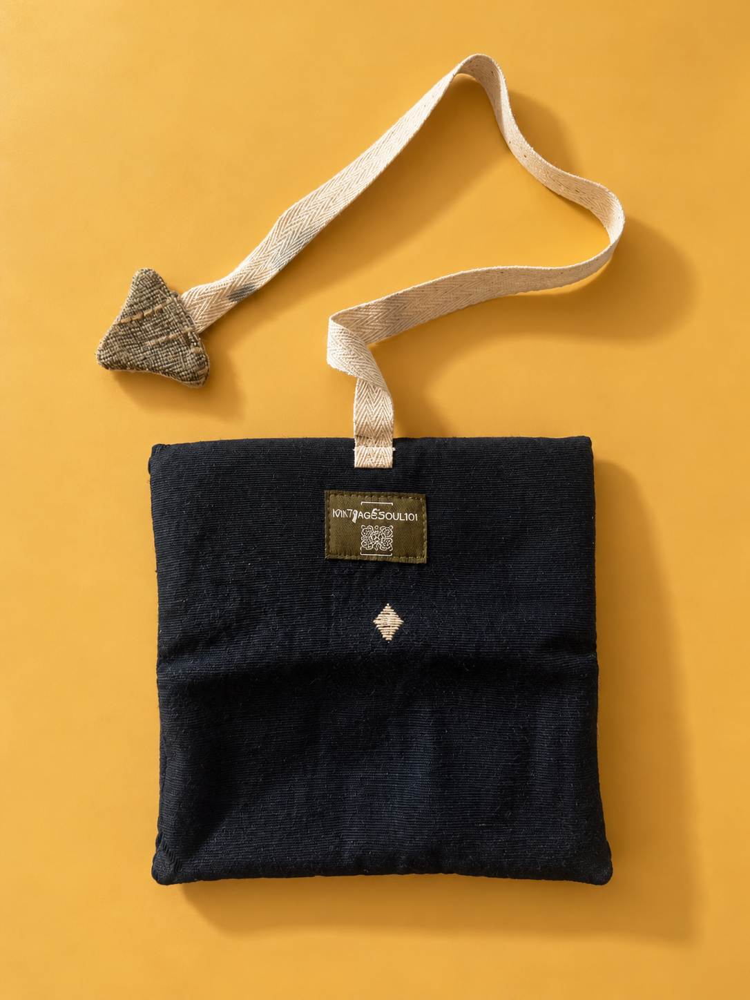 Navy pouch with cream woven strap and triangular fabric detail