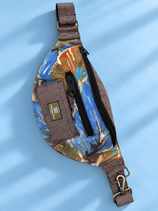 Blue and earth-tone abstract-print sling bag with brown trim on a blue background