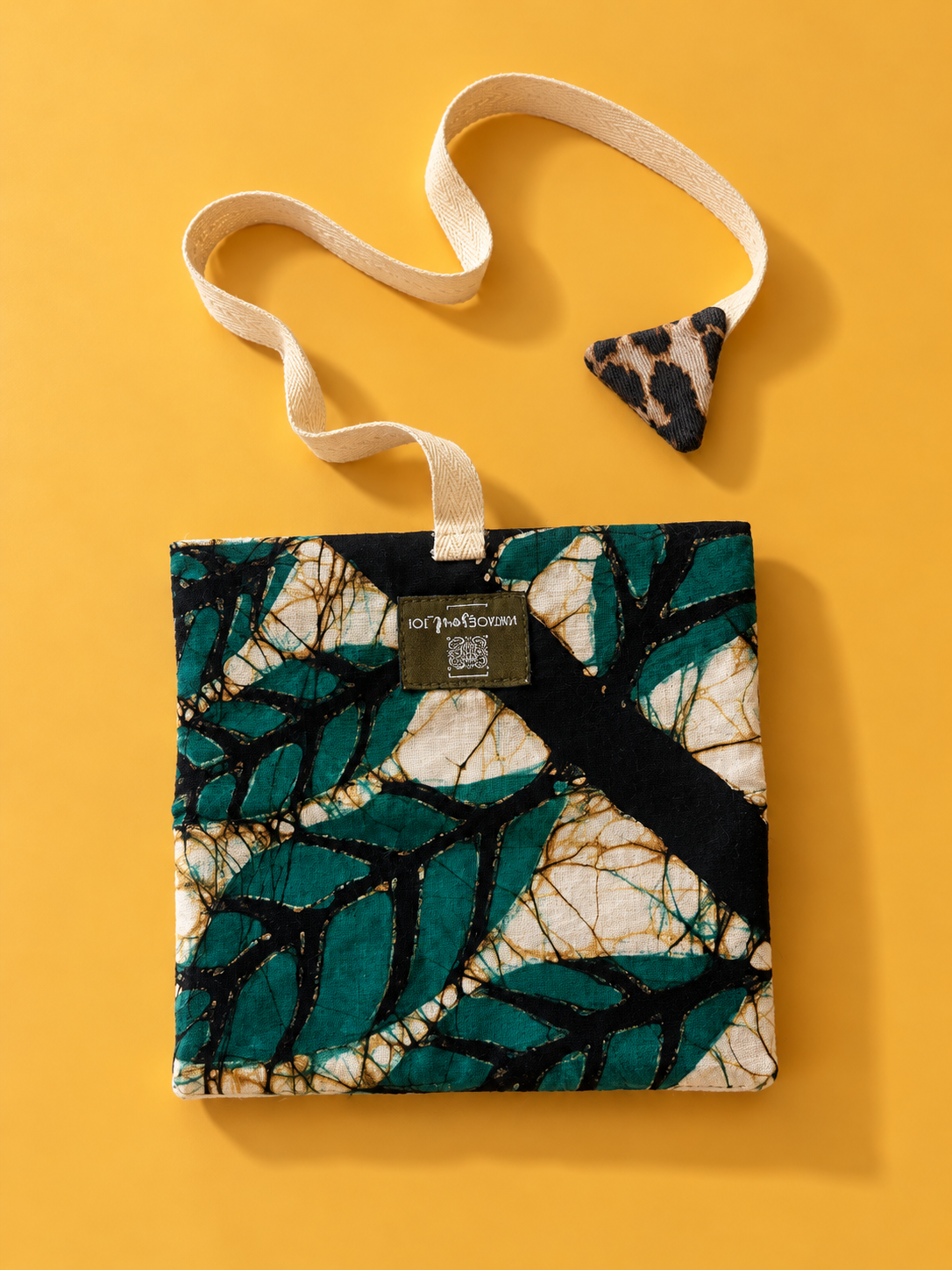Green, cream and black leaf print pouch with cream woven strap and leopard print triangular detail