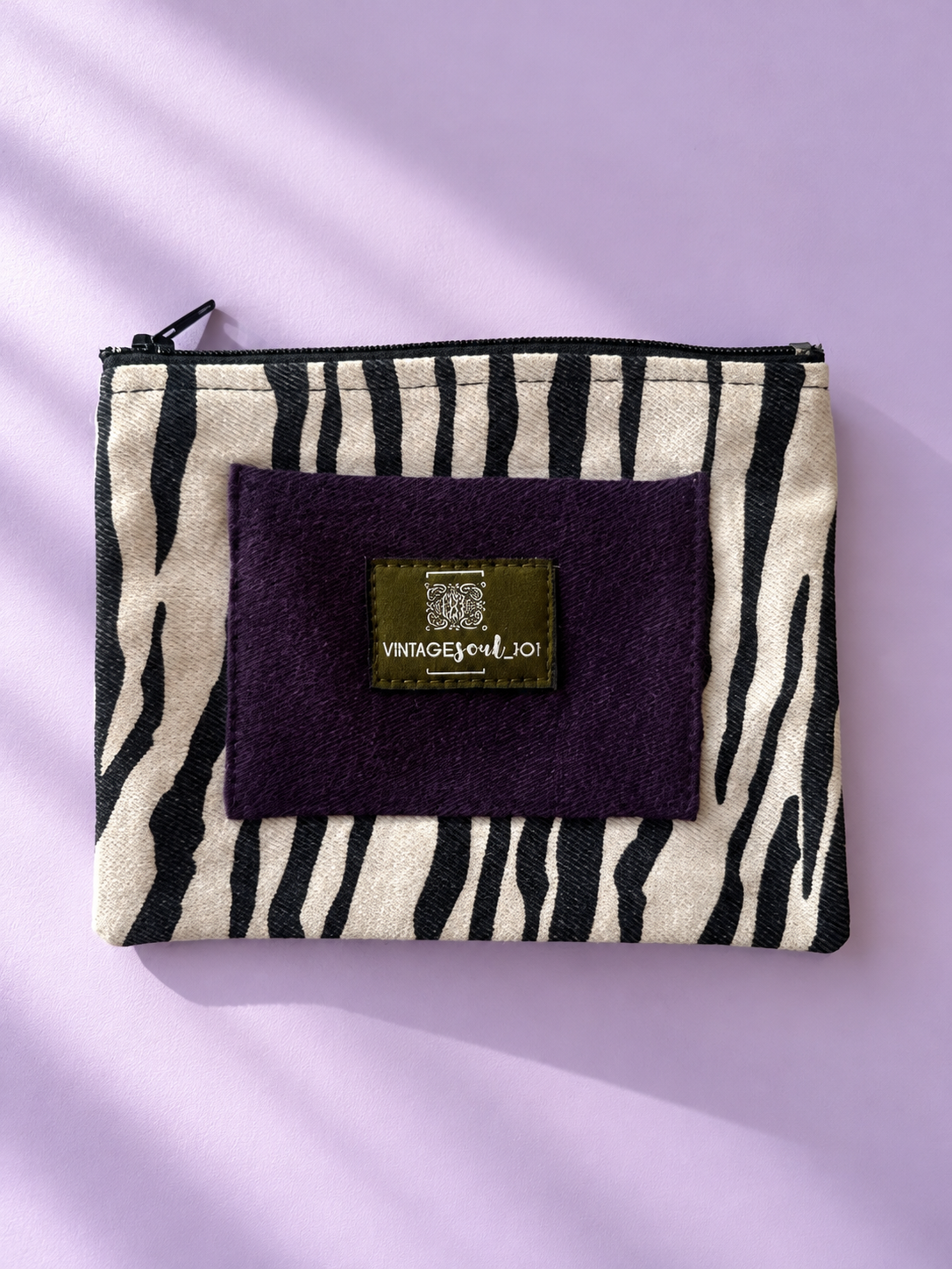 Zebra-patterned mini purse with plum panel, Vintagesoul 101 label, and black top zipper